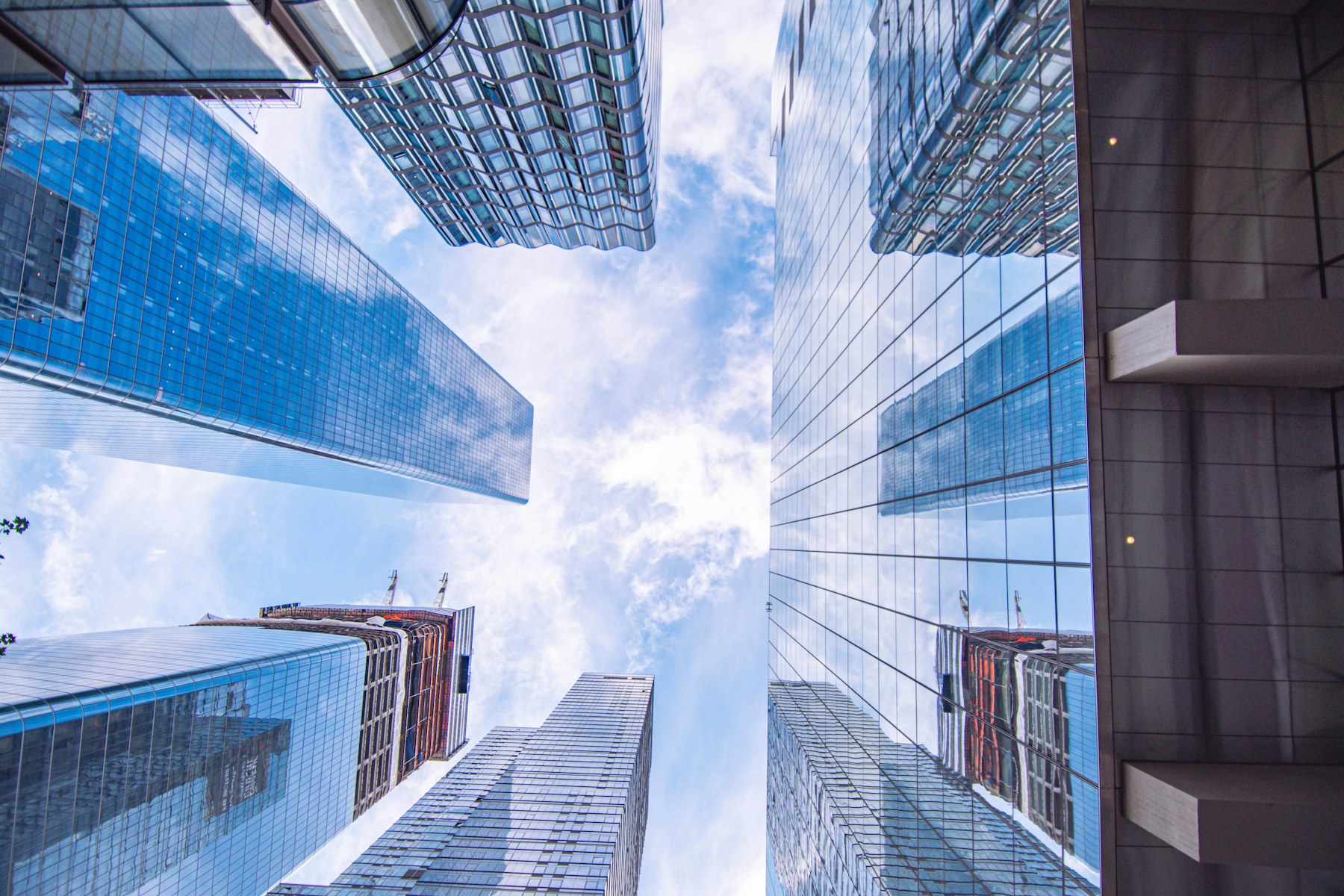 Upward perspective between modern glass office buildings